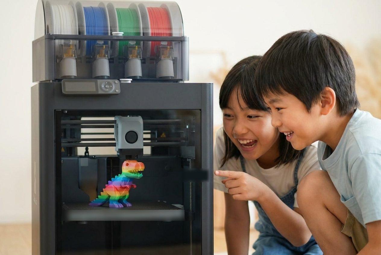 3Dプリンターで作品が印刷されるのをのぞき込む子どもたち